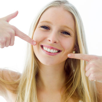 Young woman pointing at her teeth