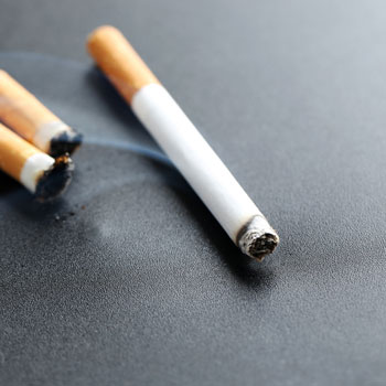 Cigarettes with ash on background